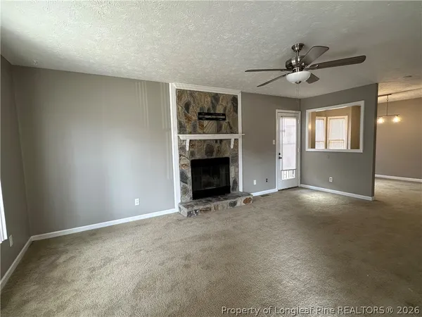a view of an empty room with window and fireplace