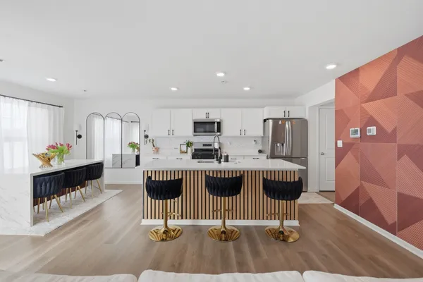 a kitchen with a sink a stove a refrigerator cabinets and a dining table
