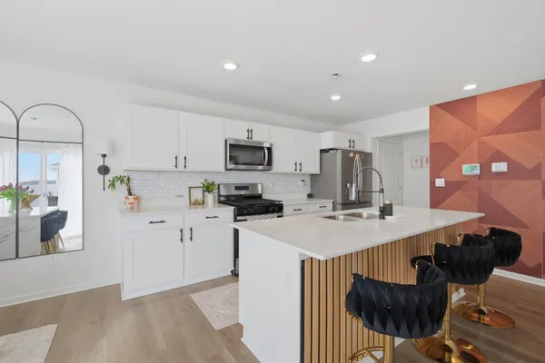 a kitchen with stainless steel appliances a sink a microwave a refrigerator and cabinets