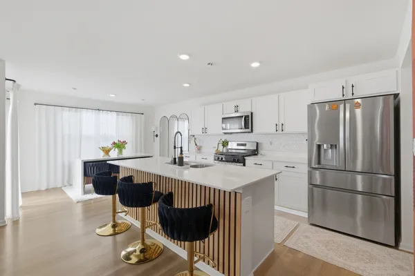 a view of kitchen with stainless steel appliances kitchen island sink stove and living room