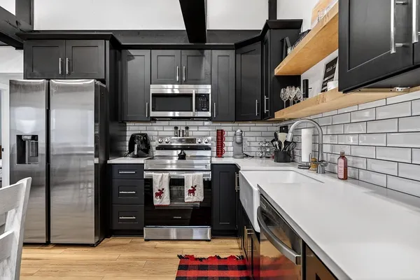 a kitchen with stainless steel appliances a sink stove and cabinets