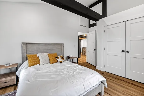 a bedroom with a bed and wooden floor