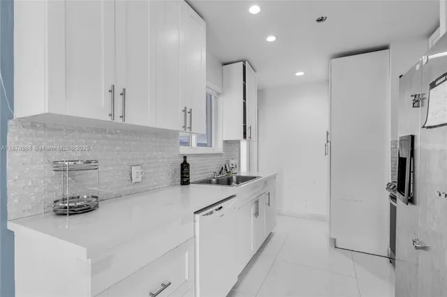 a kitchen with stainless steel appliances granite countertop a refrigerator and a stove