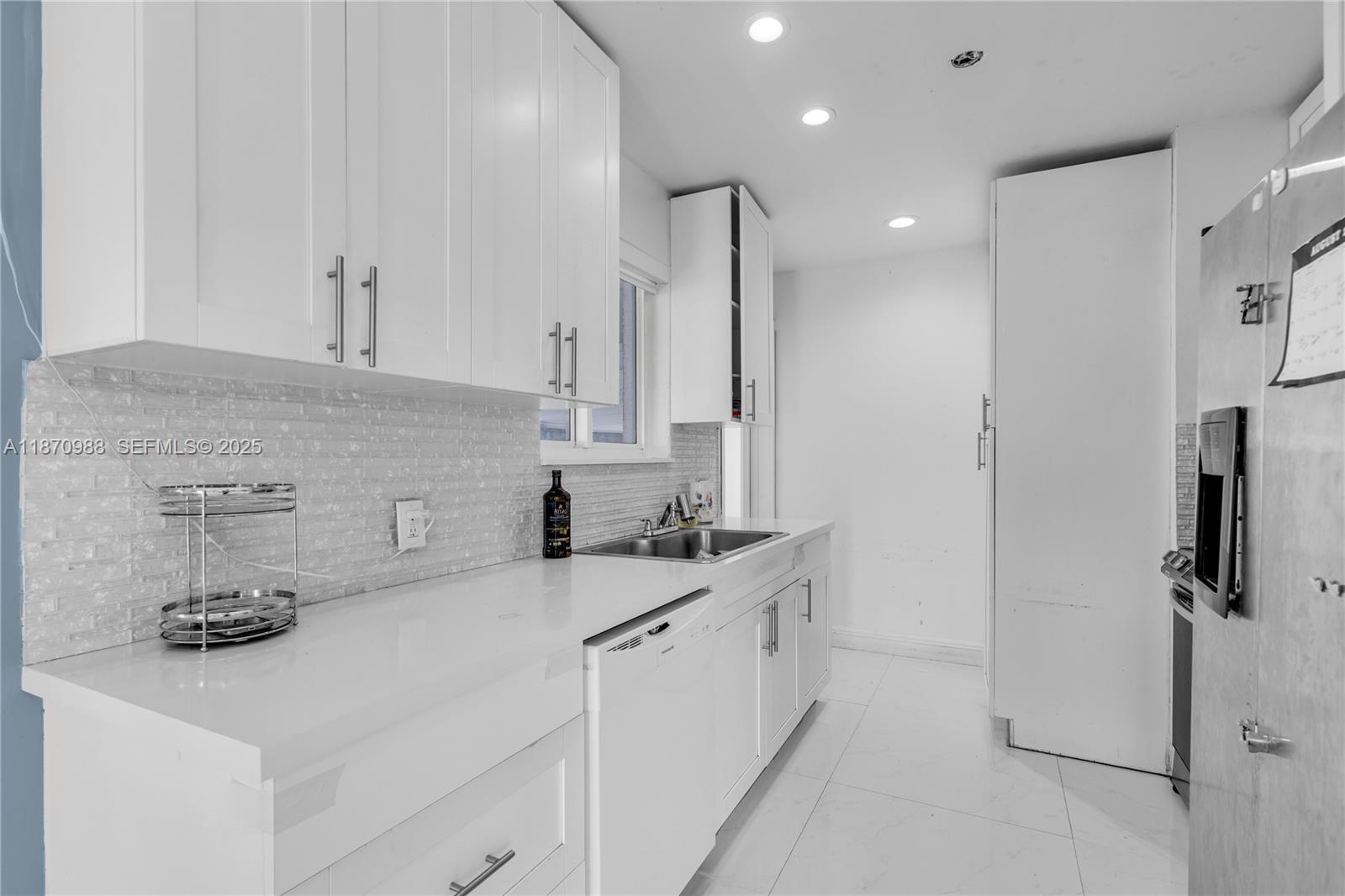 171 West 64th Street Hialeah, FL 33012 - Photo 11 of 22 a kitchen with sink a refrigerator and cabinets