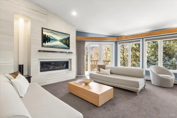a living room with furniture large window and a fireplace