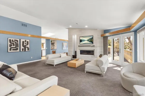 a living room with furniture fireplace and a large window