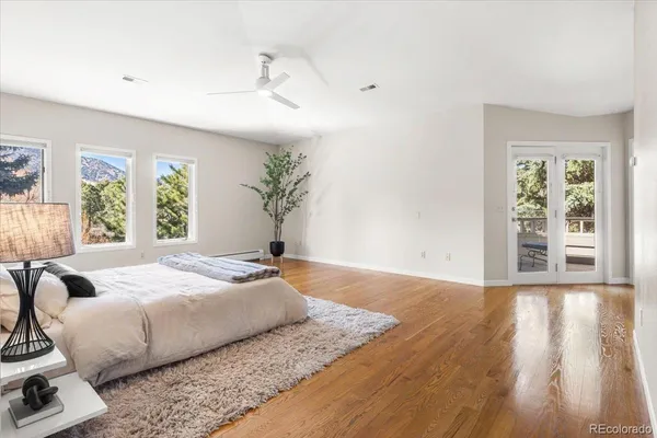 a spacious bedroom with a bed and wooden floor