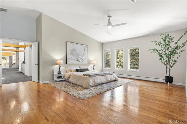 a spacious bedroom with a large bed and a chandelier