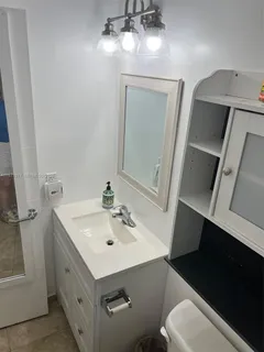 a bathroom with a toilet sink and mirror