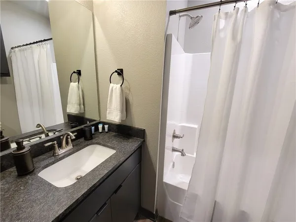 a bathroom with a granite countertop sink and a mirror