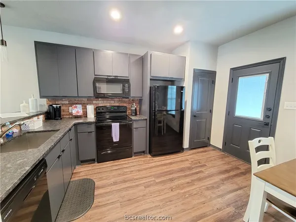 a kitchen with stainless steel appliances granite countertop a refrigerator stove and oven