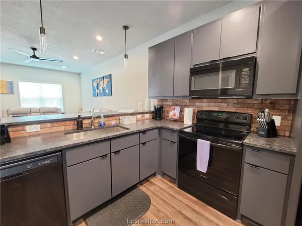 a kitchen with stainless steel appliances granite countertop a sink stove and microwave