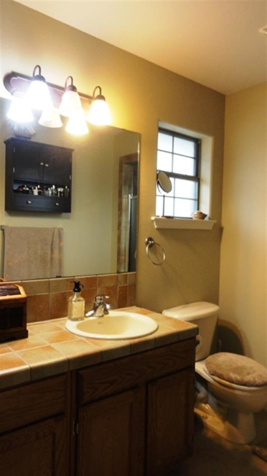 102 Sun Ray Loop Laredo, TX 78041 - Photo 6 of 9 a bathroom with a sink a toilet and mirror