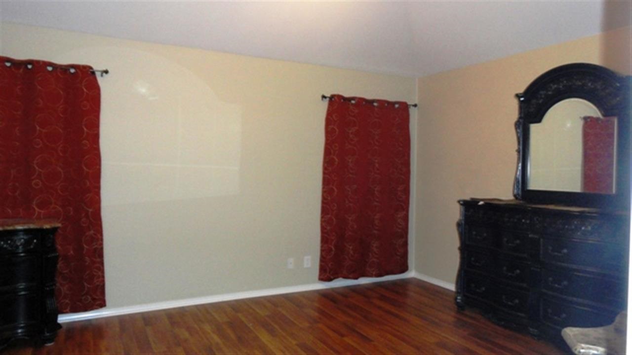 102 Sun Ray Loop Laredo, TX 78041 - Photo 7 of 9 a view of a bedroom with wooden floor and a dresser