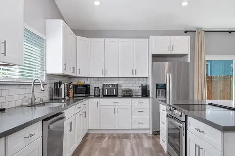 a kitchen with granite countertop a sink stainless steel appliances and cabinets