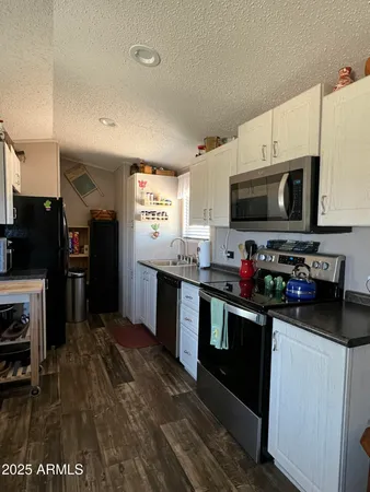 a kitchen with stainless steel appliances granite countertop a refrigerator a stove top oven a sink and dishwasher