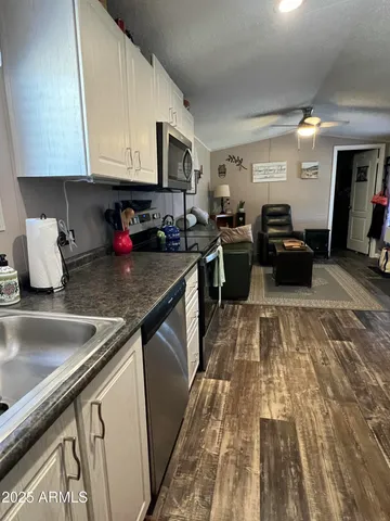 a kitchen with a stove top oven a sink a counter space and cabinets