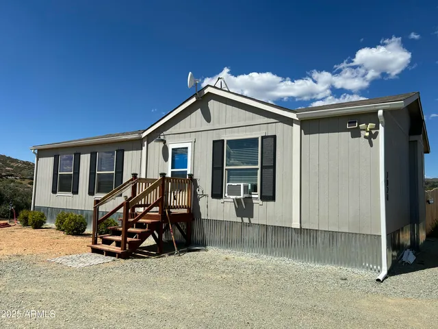 a view of a house with a patio and a yard