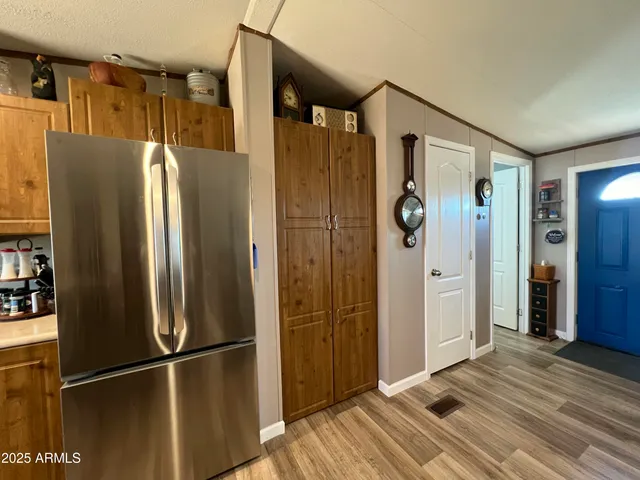 a view of a refrigerator in kitchen and wooden floor