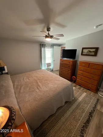 a bedroom with a bed and dresser with mirror