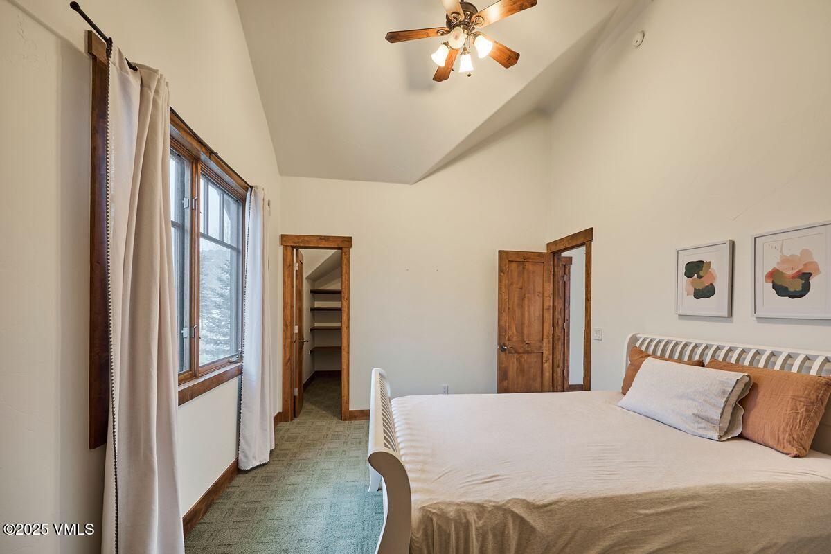 748 Hernage Creek Road Eagle, CO 81631 - Photo 34 of 44 a bedroom with a large bed and a chandelier