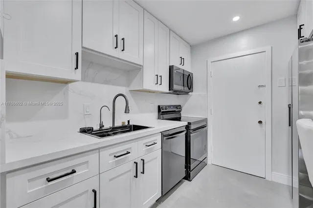 a kitchen with stainless steel appliances granite countertop white cabinets and sink