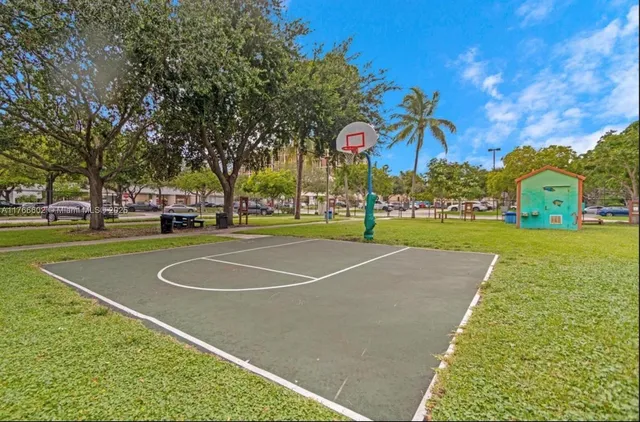 a view of a tennis ground with large trees