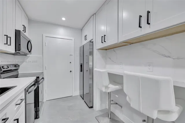 a kitchen with stainless steel appliances a refrigerator and a stove top oven