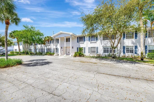 a front view of a building with a garden