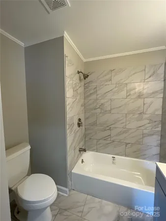 a bathroom with a toilet and bathtub