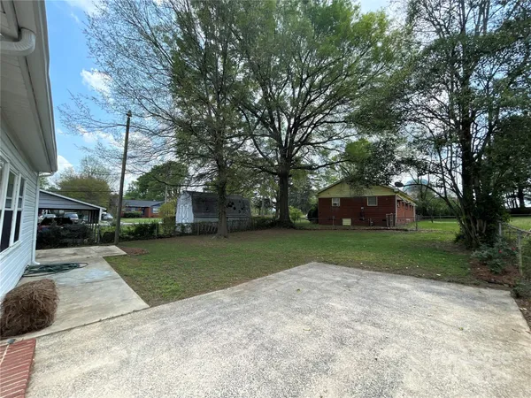 a front view of a house with a garden and trees