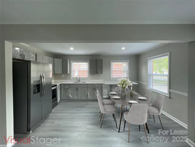 a kitchen with a table chairs refrigerator and cabinets