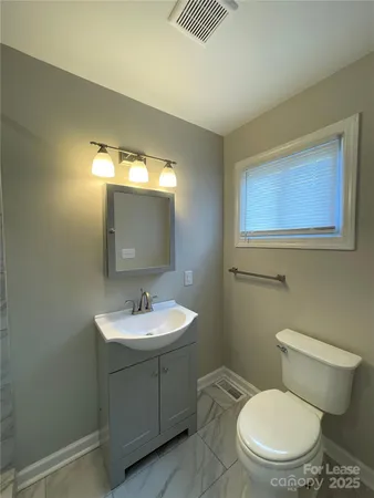 a bathroom with a toilet a sink and mirror