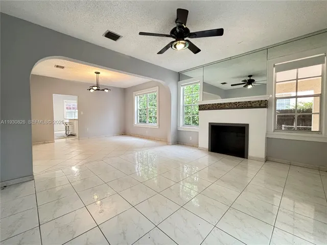 a view of an empty room with a fireplace and a window