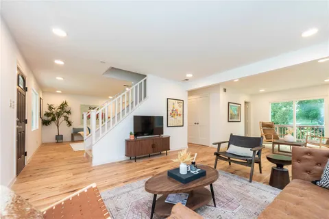 a living room with furniture and a wooden floor