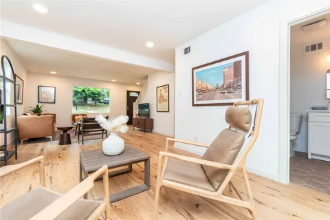 a view of a dining room with furniture a rug and wooden floor