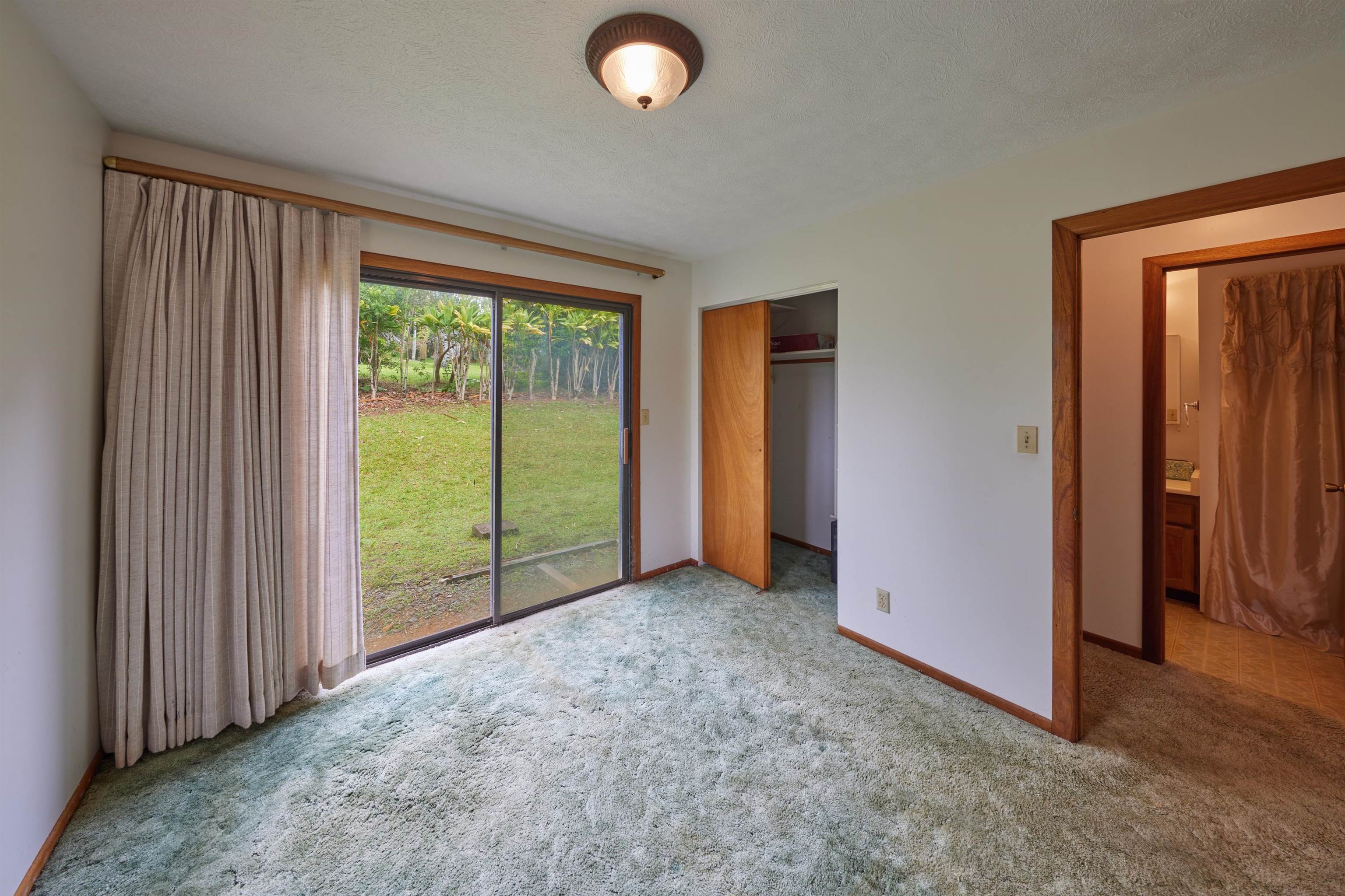 2130 Kauhikoa Road Haiku, HI 96708 - Photo 18 of 30 an empty room with sliding door and mountain view