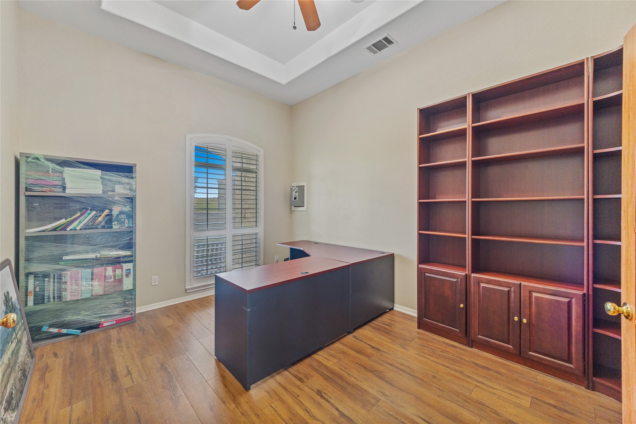20145 Janak Road Coupland, TX 78615 - Photo 13 of 40 A dedicated home office provides built-in shelving and ample workspace, all illuminated by a generous arched window.