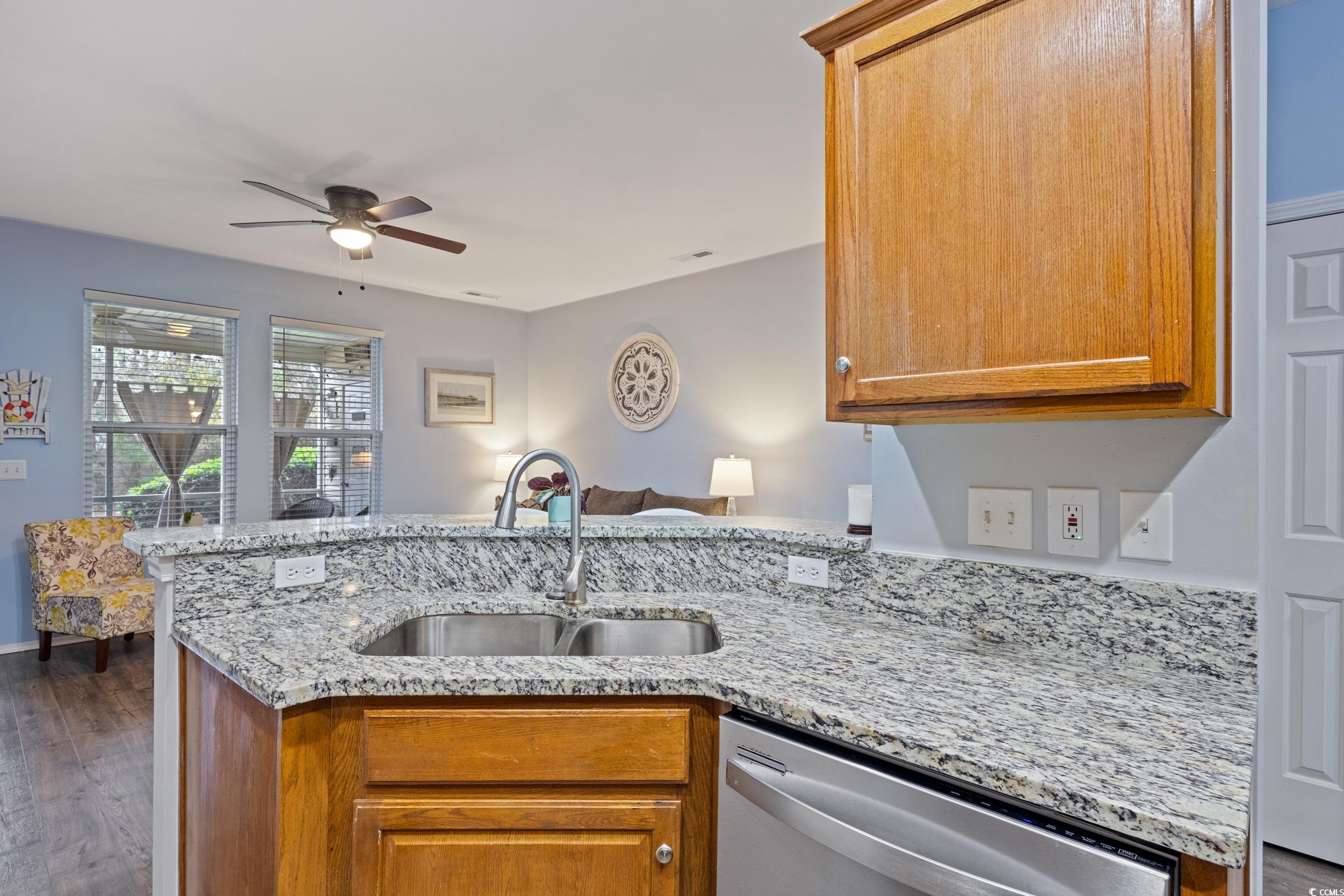 140 Olde Towne Way, Unit 2 Myrtle Beach, SC 29588 - Photo 40 of 40 Kitchen with a peninsula, brown cabinets, light stone countertops, dishwasher, and open floor plan