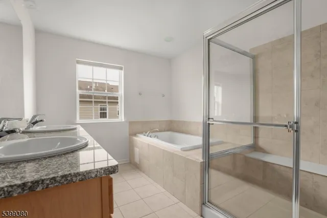 a bathroom with a granite countertop sink and a bathtub