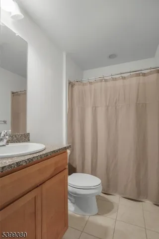 a bathroom with a granite countertop toilet and a sink