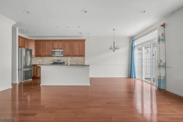 a view of kitchen with granite countertop cabinets and refrigerator