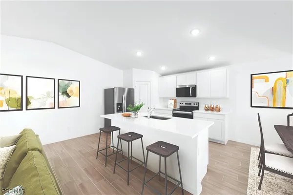 a living room with furniture a flat screen tv and kitchen view