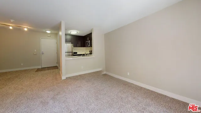 a view of a kitchen with a sink and a refrigerator