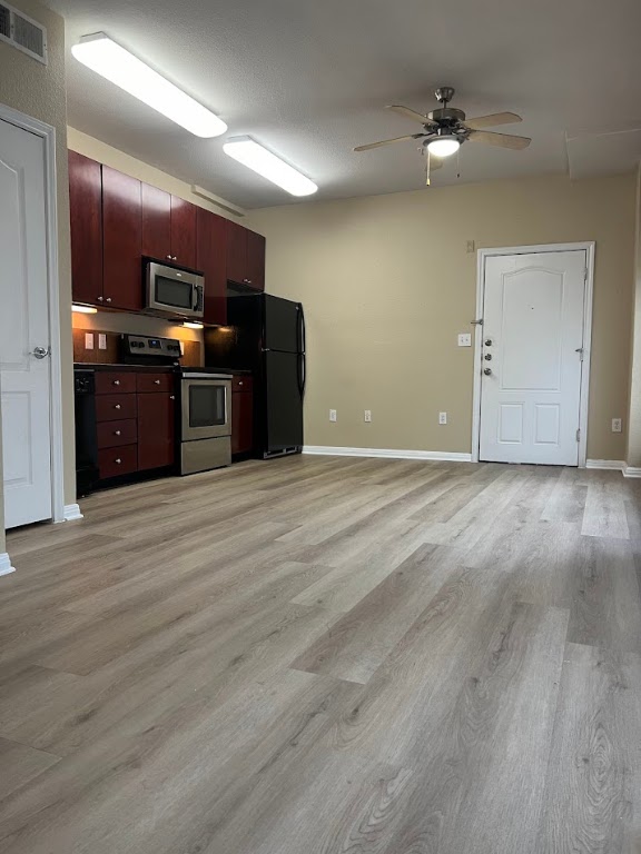 2505 San Gabriel Street, Unit 101 Austin, TX 78705 - Photo 4 of 9 a view of a kitchen with a stove cabinets and wooden floor