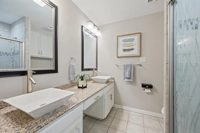 a bathroom with a granite countertop sink a mirror and a bathtub