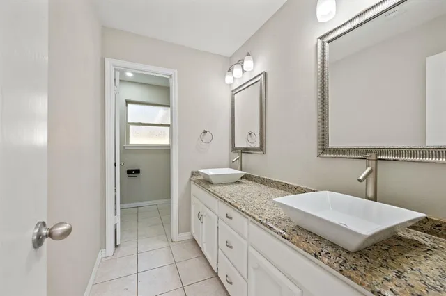 a bathroom with a granite countertop sink and a mirror