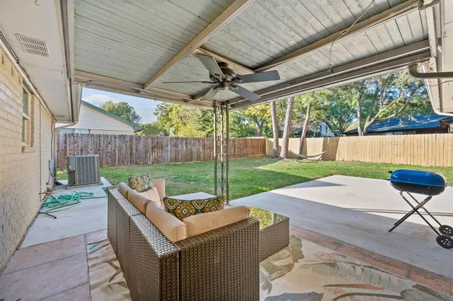 a view of a patio with a table chairs and a backyard