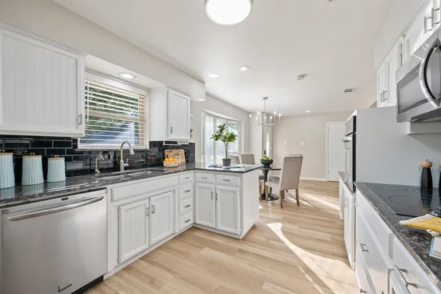 a kitchen with appliances a sink and cabinets