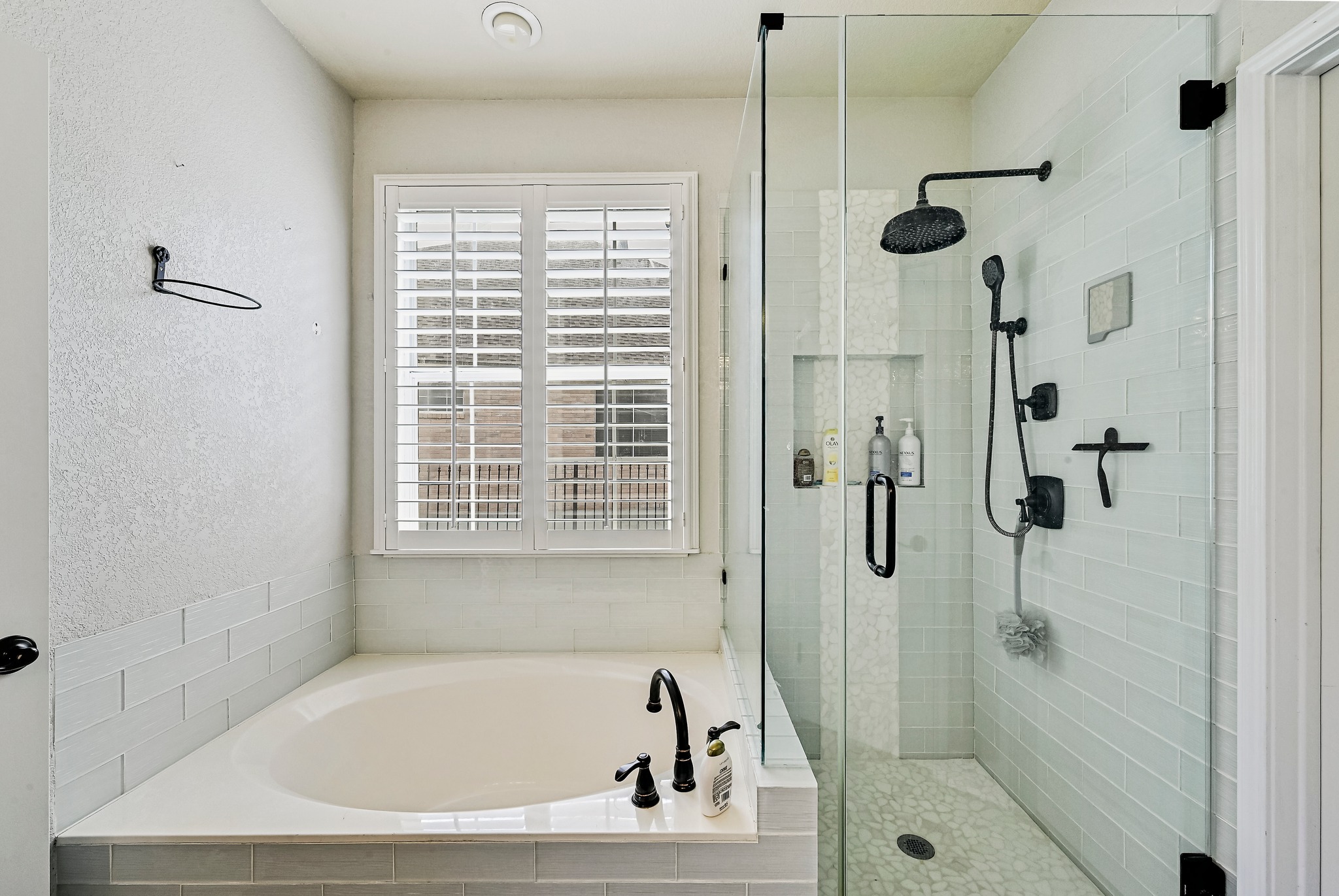 2408 Amen Corner Road Pflugerville, TX 78660 - Photo 21 of 40 Contemporary bathroom featuring a corner soaking tub and an expansive glass-enclosed shower